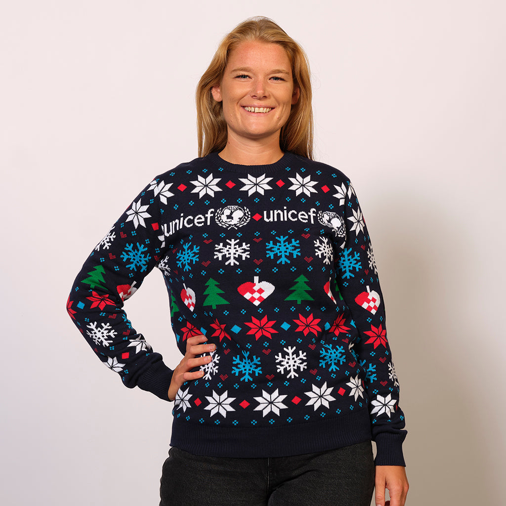 En smilende dame iført en sort unicef julesweater.